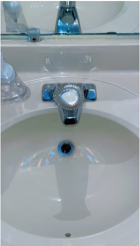 Polished bathroom sink and chrome faucet after cleaning