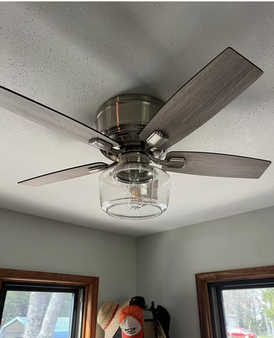 Dusted ceiling fan blades and clear glass light fixture